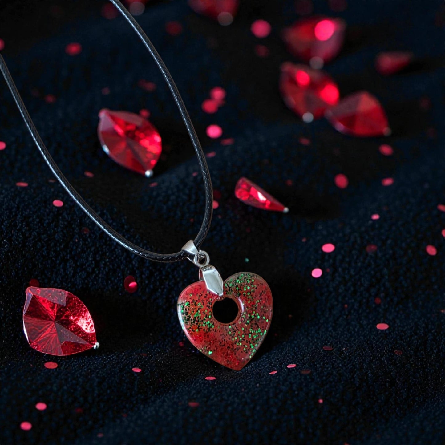 CHARM HEART Necklace – Red glittery heart with green highlights on a black cord